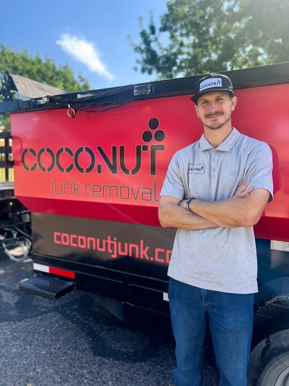Tait Neilson standing in front of the Coconut Junk Removal trailer