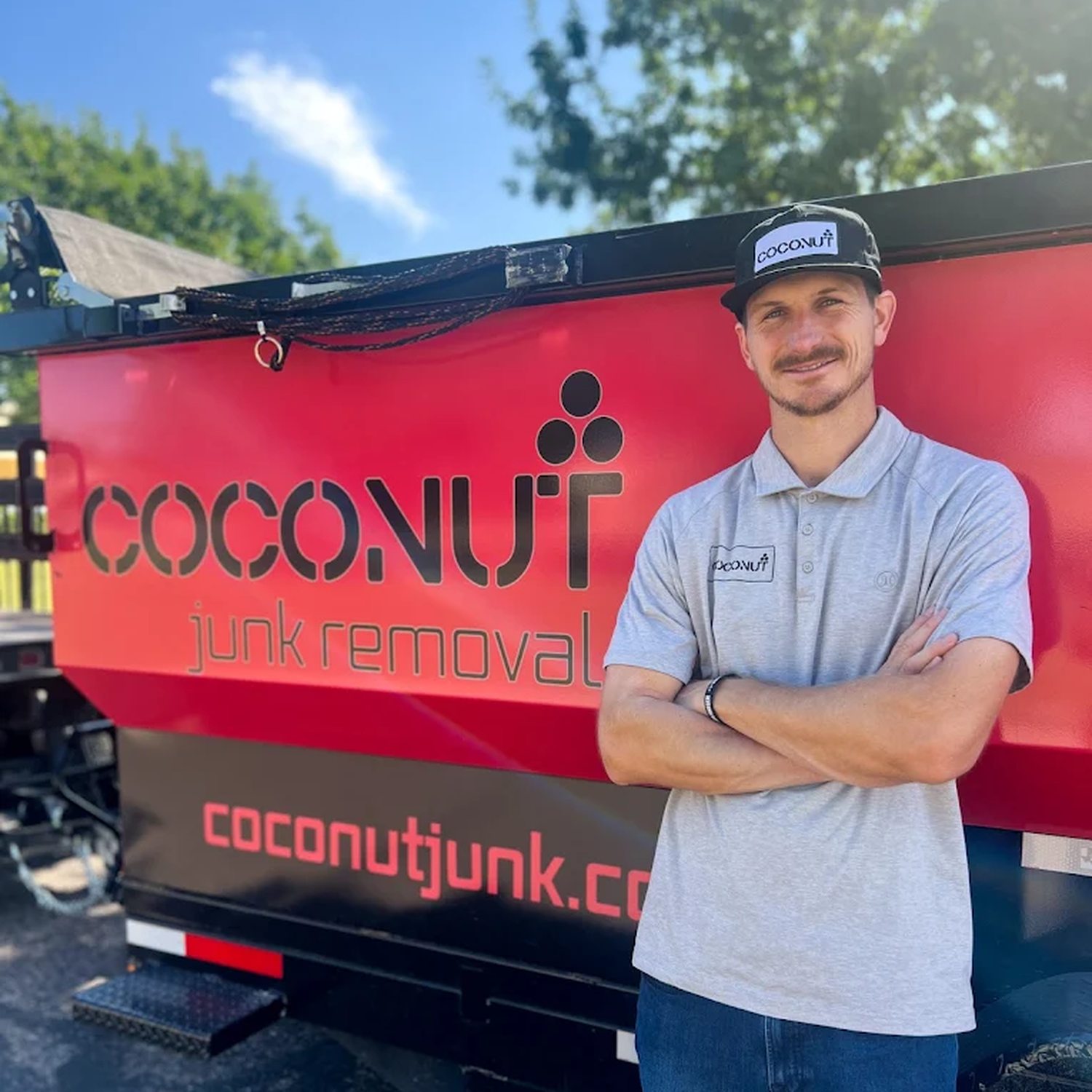 Tait Neilson standing in front of the Coconut Junk Removal trailer